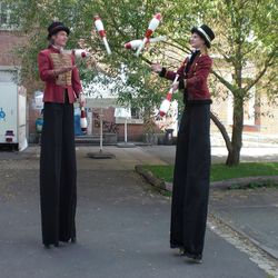 Circus-Style Zwei Stelzenläufer mit Zylinder und Jonglier-Keulen
